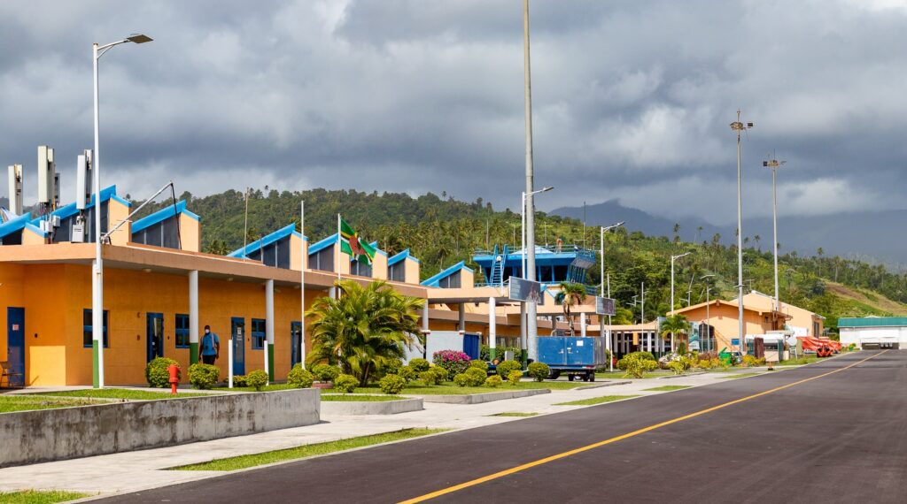 Aerial view of Douglas-Charles Airport (DOM), Dominica — runway between mountains and the Caribbean Sea